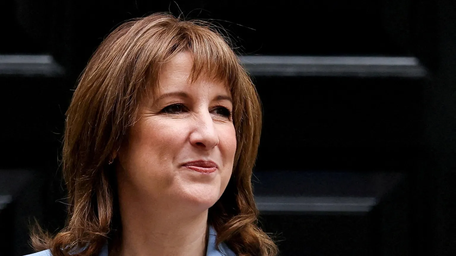 Reuters Rachel Reeves smiling in front of black Downing Street door
