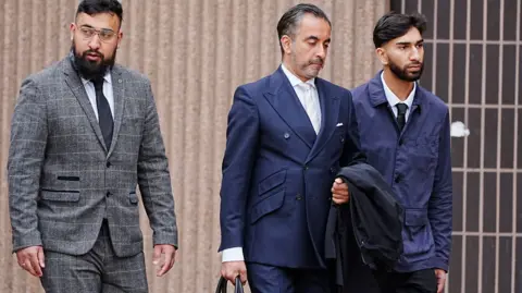 PA Media Human Rights lawyer Aamer Anwar (centre) arrives with Muhammed Amaad (left) and Mohammed Fahir Amaaz (right) at Liverpool Crown Court