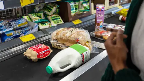 Getty Images Eggs, bread, milk, and other food on a conveyor belt
